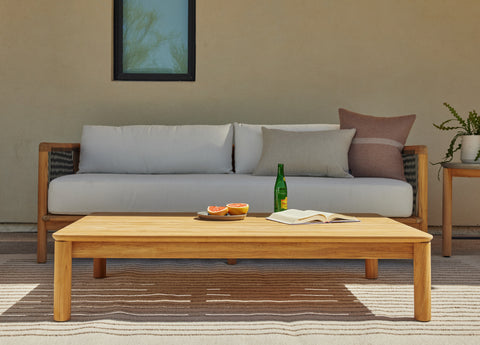 Teak coffee table in front of an outdoor sofa