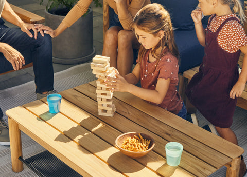 Girl playing with blocks on outdoor coffee table